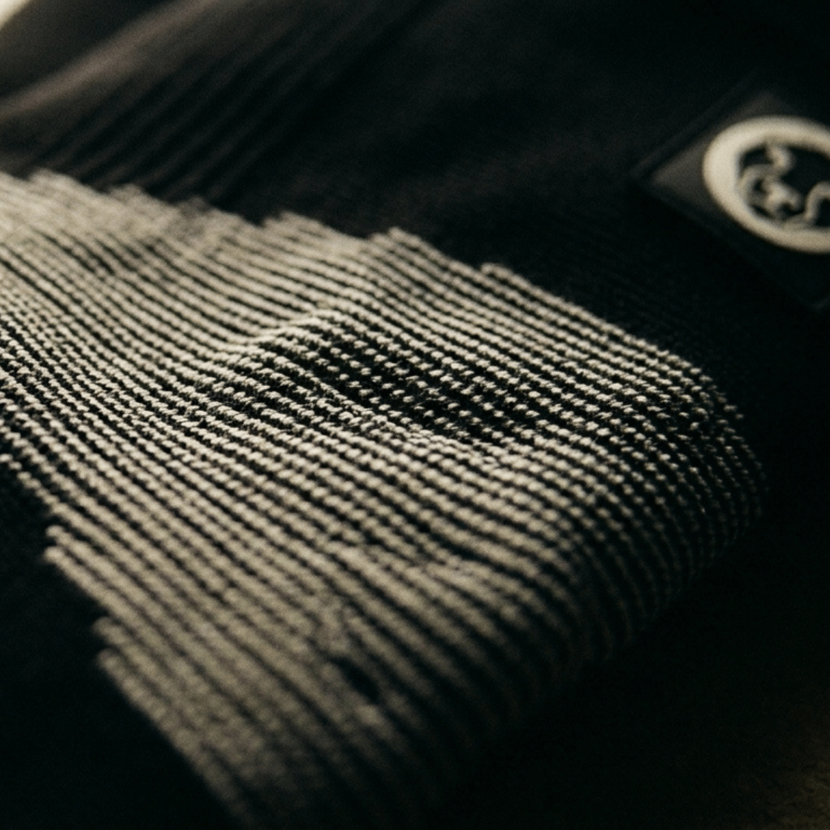 Mammal Thermal Knee Sleeves – close up of thermal knit compression fabric and Mammal Strength logo